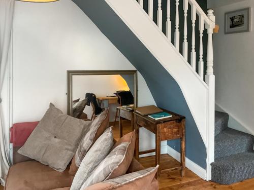 ein Wohnzimmer mit einem Sofa und einer Treppe in der Unterkunft Archers Cottage in Birley