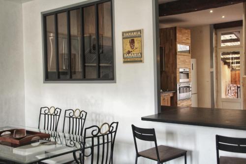 een keuken en eetkamer met een tafel en stoelen bij La Maison des Mousquetaires in Condom