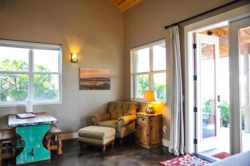 a living room with a couch and a chair and windows at Entire Property Rental for Large Groups Sleeping 40+ Guests with Pool and Fire Pit in Texas Hill Country near Austin, Texas in Hammetts Crossing