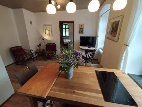a dining room with a wooden table with a vase of flowers at Ferienwohnung Sauerland Burgfenster in Bilstein