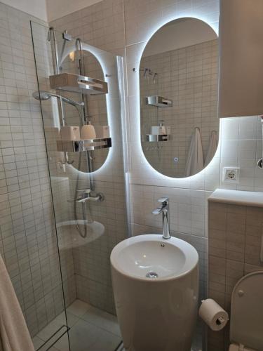 a bathroom with a sink and a shower with a mirror at Apartments iris in Brela