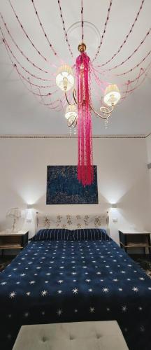 a bedroom with a blue bed with a chandelier at Giardino Principi Dafagi in Capurso