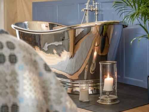 a bath tub with candles on a table with a candle at Gwenllian in Machynlleth