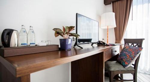 a room with a desk with a chair and a mirror at The Bridge Residence Hotel in Kanchanaburi