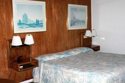 a hotel room with a bed and two lamps at Motel 101 in Gold Beach