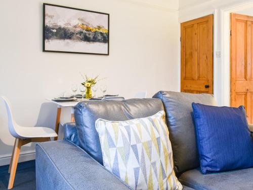 a living room with a blue couch and a table at Prospect Cottage in Skipton
