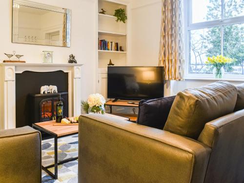 ein Wohnzimmer mit Sofa und Fernseher in der Unterkunft Prospect Cottage in Skipton