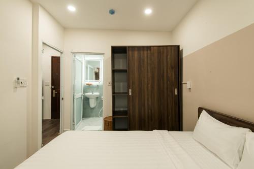 un dormitorio con una cama y un baño en Cashew Inn, en Ho Chi Minh