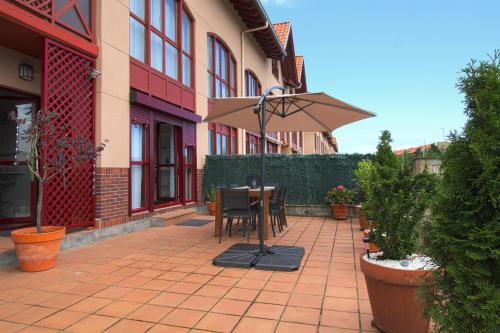 a patio with a table and an umbrella at Apartamento Aventuras in Comillas
