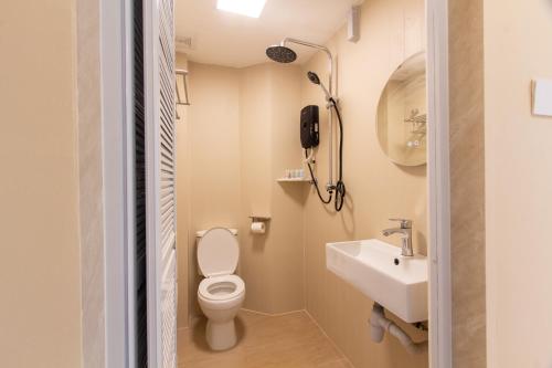 a small bathroom with a toilet and a sink at Blenz Hotel in Serdang