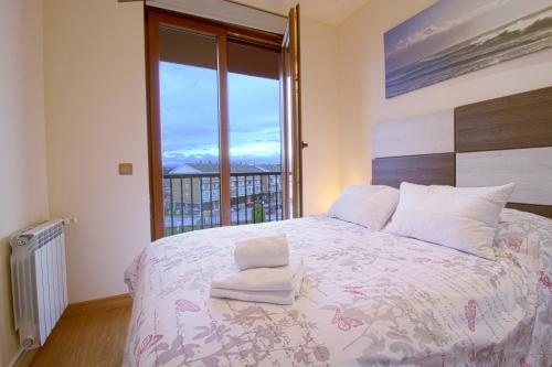 a bedroom with a large bed with a large window at La Casa del Muelle in Suances