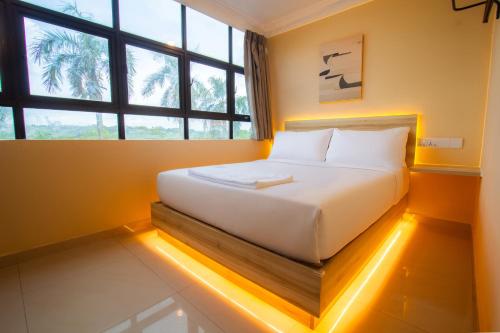 a bed in a room with a large window at Blenz Hotel in Serdang