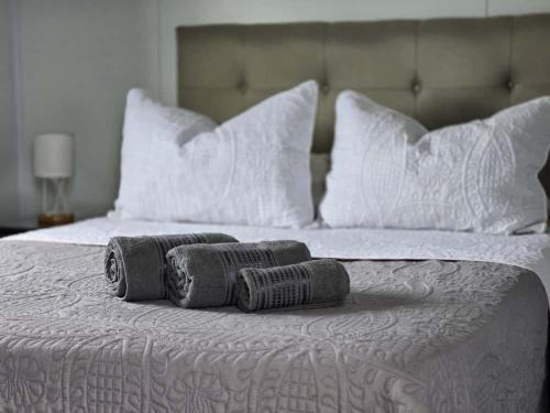 a bed with white pillows and two towels on it at Maridalba 2 in La Coronilla