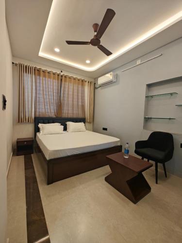 una camera con letto, sedia e ventilatore a soffitto di Narayani Villa a Udaipur