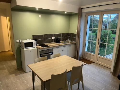 a kitchen with a table and a table and chairs at Appartement cosy rénové dans une ancienne longère in Chemilly-sur-Yonne