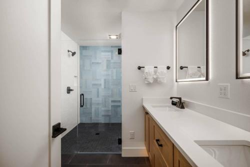 a white bathroom with a sink and a shower at Lake & Laughter Unit 2 in Rockaway Beach