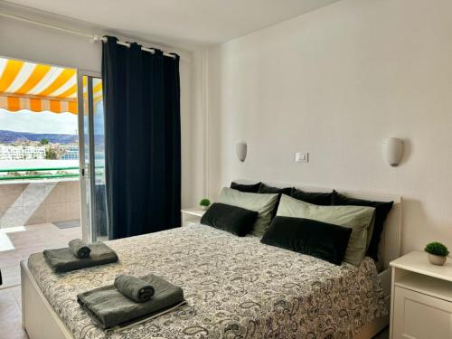 a bedroom with a bed with two towels on it at playa del cura apartment with terrace in Mogán