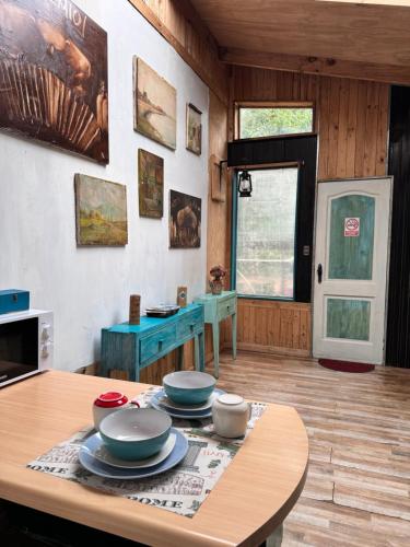 una cocina con una mesa con tazones y platos. en Apartamento Hortensias del Lago, en Puerto Varas