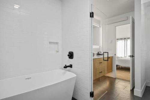 a white bathroom with a tub and a sink at Lake & Laughter Unit 1 in Rockaway Beach