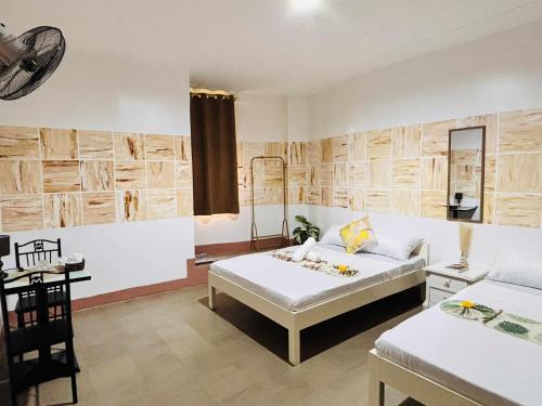 ein Schlafzimmer mit einem Bett, einem Schreibtisch und einem Tisch in der Unterkunft Golden Sunn Tourist Inn in Puerto Princesa