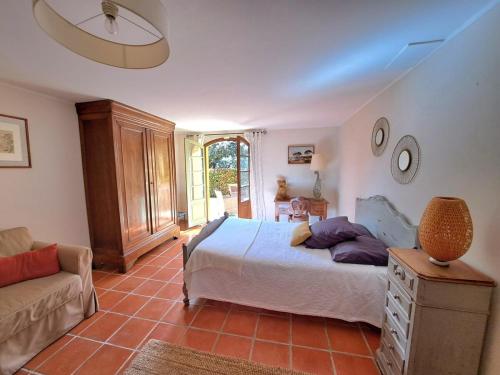 a bedroom with a bed and a couch at Rez de jardin villa Presqu'ile de Giens in Hyères