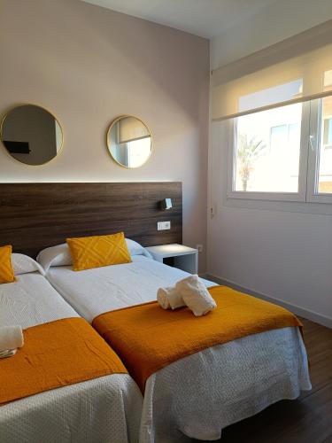 a bedroom with two beds and two mirrors on the wall at Marynton Boutique in Benicarló