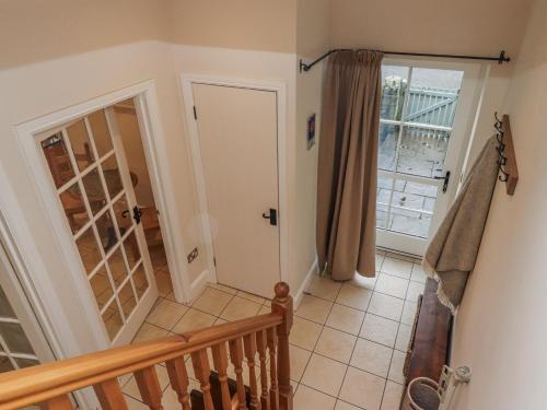 a room with a staircase and a door with a staircase at Watermill Cottage in Chathill