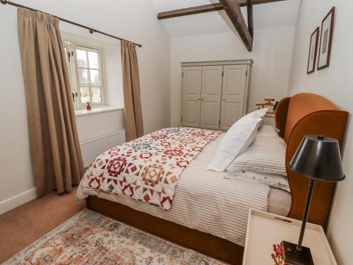 a bedroom with a bed and a window at Watermill Cottage in Chathill