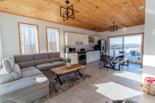 una sala de estar con un sofá y una mesa en Chalet au Mont-Édouard, Les 3 Versants 38B, en L'Anse-Saint-Jean