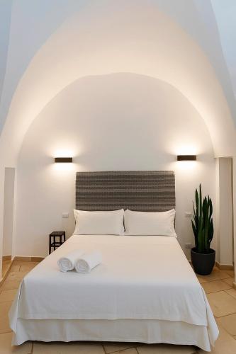 a bedroom with a white bed with two towels on it at B&B Salentus in Gallipoli