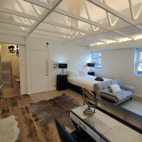 a large bedroom with a bed and a couch at London loft by let it b travel in London