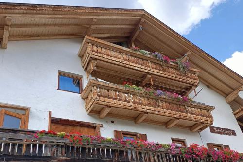 un edificio con balconi in legno e fiori di Lüch Dl Pinter ad Antermoia