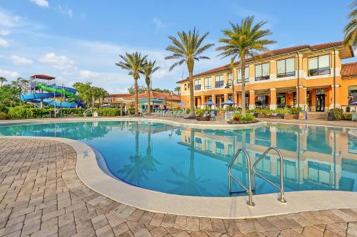 a swimming pool at a resort with palm trees at Regal Oaks Resort Vacation Townhomes by IDILIQ in Orlando