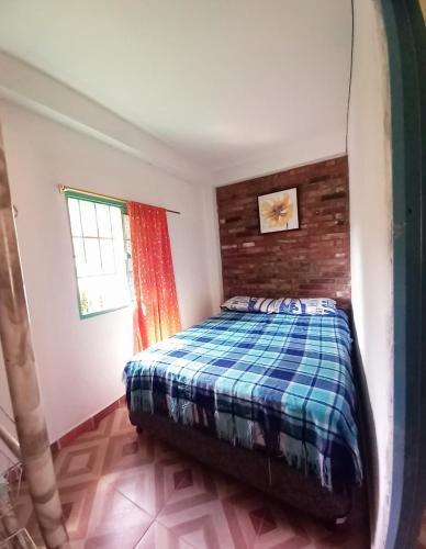a bedroom with a bed with a plaid blanket at Villa Celeste in Páramo