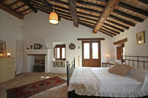una camera da letto con un letto in una stanza con camino di Italian Experience-Villa la Dolcevita a Montegiorgio