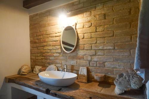 bagno con lavandino bianco e parete in mattoni di Italian Experience-Villa la Dolcevita a Montegiorgio