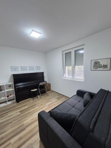 een woonkamer met een bank en een piano bij The Music Box in Skopje