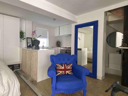 a blue chair in a room with a kitchen at London loft by let it b travel in London
