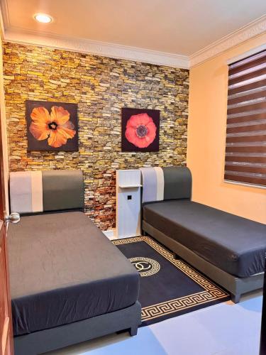 クライにあるPlus Homestayのレンガの壁、ベッド2台が備わるベッドルーム1室が備わります。