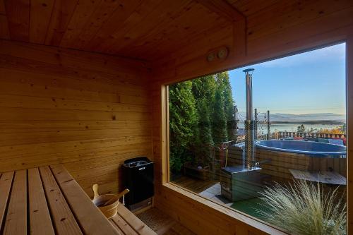 a room with a large window in a wooden cabin at Villa Beskidzka 100 - SAUNA & BALIA z Jacuzzi Widok na góry i jezioro żywieckie in Zarzecze