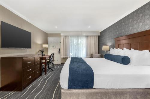 a hotel room with a large bed and a desk at Best Western Plus Carriage Inn in Sherman Oaks