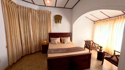 a bedroom with a bed in a room with curtains at Ceylon Bliss Retreat- Kandy Wellness Hotel in Kandy