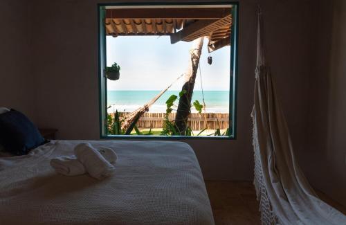 a bedroom with a bed with a view of the ocean at Casa Paracatoá - Icapuí in Icapuí