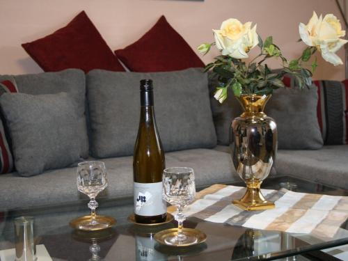 a bottle of wine sitting on a table with glasses at Ferienwohnung Bilstein in Bilstein