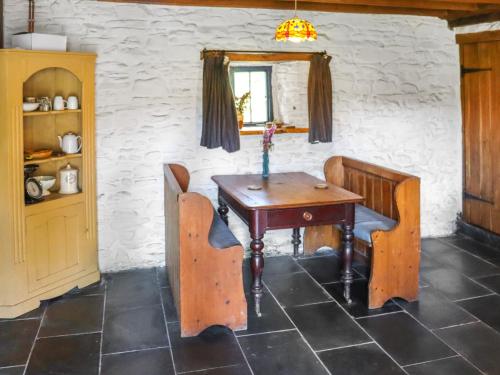 - une table et des chaises en bois dans l'établissement Thatched Cottage - Uk50261, à Llandeilo