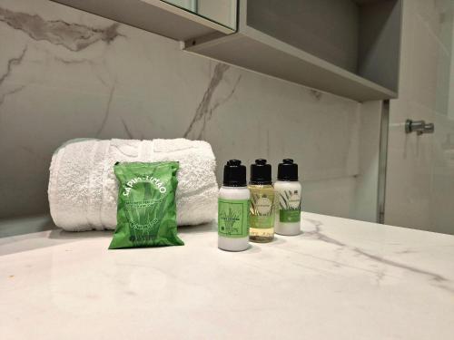 a bathroom with two bottles of shampoo and a towel at CURTA!|216|Brava Arts|2 Suítes| Sofisticada Vista in Cabeçudas