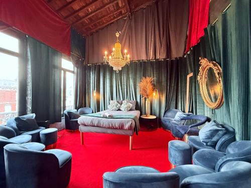 a room with blue chairs and a bed and a chandelier at 10 Très Grande Chambre insolite double volume XL, proximité gare de tourcoing in Tourcoing