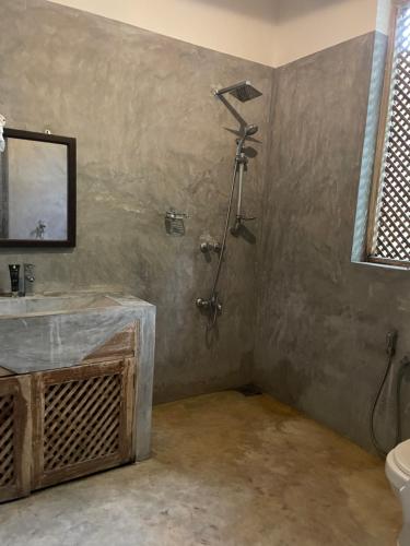a bathroom with a shower and a sink and a mirror at Lali Villa in Galle