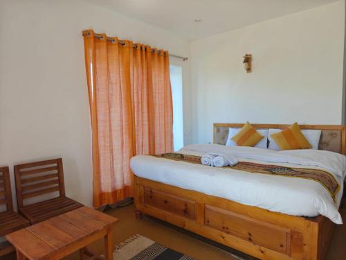 a bedroom with a bed and a chair at Buransh Retreat in Jageshwar