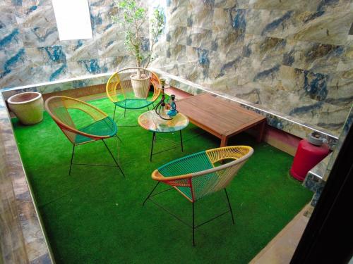 une terrasse avec 3 chaises et une table avec de l'herbe verte dans l'établissement home away from home 2 bedroom luxury apartment gulize, à Marrakech